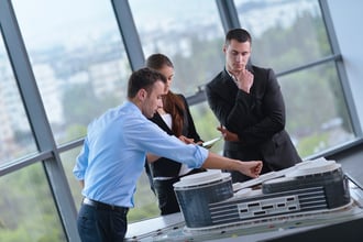 business people group on meeting and presentation in bright modern office with construction engineer architect and worker looking building model and blueprint plans