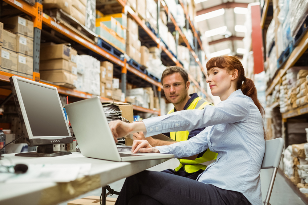 A full time employee training a temporary warehouse worker